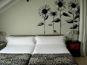
a bed with a white comforter and two pillows at Hotel el Jardín de Eugenia in Ribadesella
