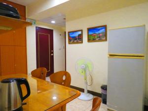 uma cozinha com uma mesa e um frigorífico com uma ventoinha em eZ Stay Juifen(Ruifang Station) em Ruifang