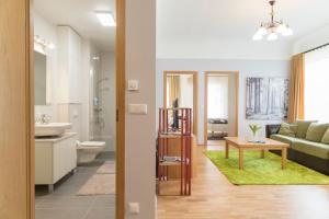 a bathroom and a living room with a couch and a table at Saaresalu City Center Apartment in Pärnu