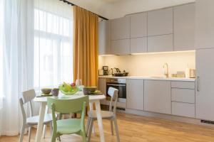 a kitchen and dining room with a table and chairs at Saaresalu City Center Apartment in Pärnu