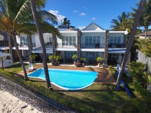 an aerial view of a resort with a swimming pool and palm trees at Garden Villas in Grand-Baie