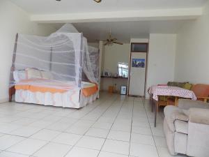 a bedroom with a bed with a mosquito net at Sunrise Apartments Hotel Fort Portal in Fort Portal