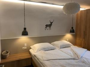 ブルック・アン・デア・ムーアにあるFerienwohnung Sailerのベッドルーム1室(壁に鹿が1匹いるベッド1台付)