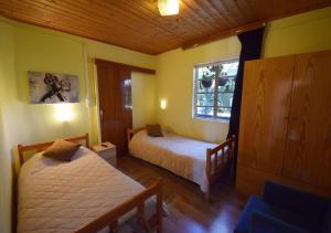 a bedroom with two beds and a window at Christys Palace Hotel in Pedoulas