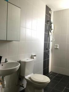 La salle de bains est pourvue de toilettes et d'un lavabo. dans l'établissement Sandakan Spacious and Comfortable Pool View Condo, à Sandakan