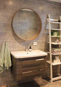 ein Bad mit einem Waschbecken und einem Spiegel in der Unterkunft City View Studio Apartment in Ålesund