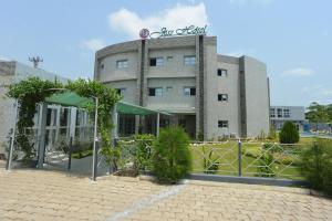 a building with a garden in front of it at Jess Hotel Kpalimé in Palimé