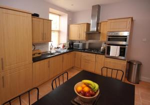 a kitchen with a bowl of fruit on a table at Sebright Holiday Apartment in Dunoon