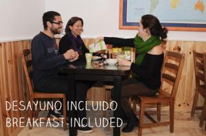 a woman sitting at a table with two men at Hostel Triana Backpackers in Seville