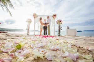 a wedding ceremony on the beach with flowers on the beach at Secret Garden Beach Resort in Bangrak Beach