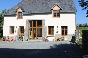 a white house with a large door and windows at Normandy Gite Holidays in Lengronne