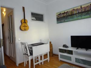 a room with a desk and a guitar on the wall at Bom dia Porto in Vila Nova de Gaia