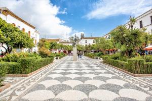 una pasarela de azulejos en una ciudad con edificios en The Old Town Apartment, en Marbella