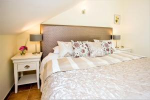 een slaapkamer met een groot bed met kussens en 2 tafels bij The Old Town Apartment in Marbella
