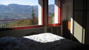 a bedroom with a bed and a view of mountains at Villa Bellavista in Sestola