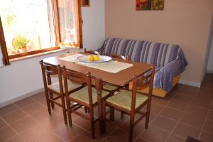 a table and chairs with a plate of fruit on it at Appartamenti Da Vincenza in Santa Maria Navarrese +49 photos