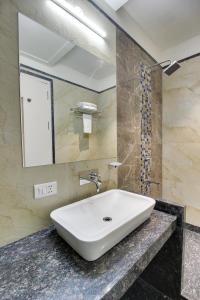 La salle de bains est pourvue d'un lavabo et d'un miroir. dans l'établissement Red Carlton, à Kanpur