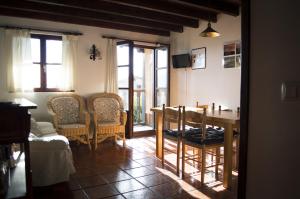 a living room with a table and chairs and windows at Apartamento Fuente De Somave in Cahecho