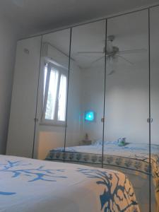 1 dormitorio con espejo grande y cama en Manfredonia - Ippocampo Seaside Home, en Ippocampo