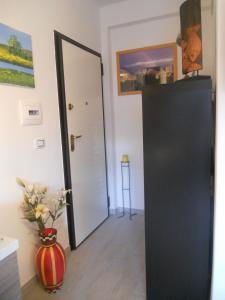 una puerta negra en una habitación con un jarrón en Manfredonia - Ippocampo Seaside Home, en Ippocampo