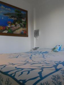 1 cama en una habitación con un cuadro en la pared en Manfredonia - Ippocampo Seaside Home, en Ippocampo