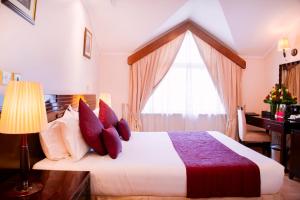 a bedroom with a large bed with a window at Boma Inn Nairobi in Nairobi