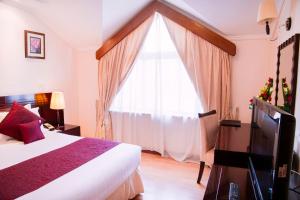 a bedroom with a bed and a large window at Boma Inn Nairobi in Nairobi