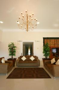 a living room with two couches and a chandelier at Zar San Luis Potosi in San Luis Potosí