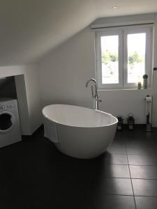 uma banheira branca na casa de banho com uma janela em Business Appartements em Heppenheim an der Bergstrasse