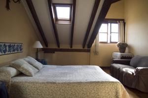 a bedroom with a bed and a couch and two windows at Apartamento Fuente De Somave in Cahecho