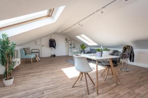 an attic living room with a table and chairs at Boutique Apartments Kirchzarten in Kirchzarten