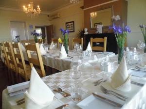 a dining room with a table with white tablecloths and flowers at Waterfront Hotel in Deal