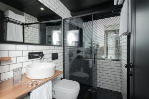 a bathroom with a toilet, sink, and mirror at Hotel Cinnah in Ankara