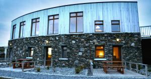 a stone building with two benches in front of it at Dolphin Hotel in Inishbofin