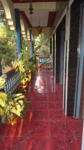 a hallway of a building with a red tile floor at Naga Palace in Gokarna