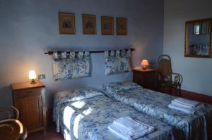 a bedroom with two beds and two tables and two lamps at Agriturismo Scorgiano in Scorgiano