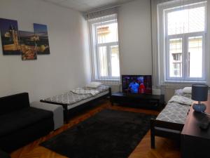 a living room with two beds and a tv at Akos Apartman in Eger