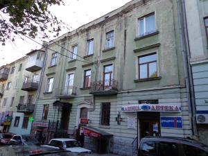 テルノーピリにあるApartment on Shevchenka Boulevardの通りに面した建物とその前に駐車された車