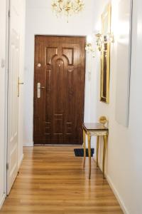 a hallway with a wooden door and a table at Gold Box Apartament in Gdańsk