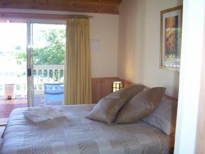 1 dormitorio con cama con almohadas y balcón en Yarra Glen Bed & Breakfast en Yarra Glen