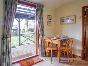 a dining room with a table and chairs and a sliding glass door at 7 The Uplands in Thorpeness