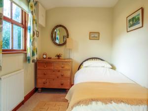 1 dormitorio con cama, tocador y espejo en 7 The Uplands, en Thorpeness