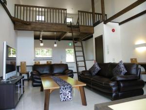 uma sala de estar com um sofá e um loft em Chalet Fuyuri em Furano