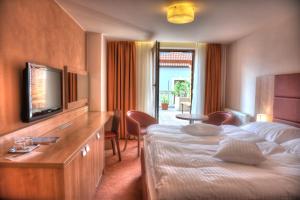 a hotel room with a bed and a television at Hotel Club in Kežmarok
