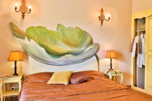 a bedroom with a large painting on the wall at Hostellerie du Cigalou - Teritoria in Bormes-les-Mimosas