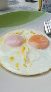 two fried eggs on a plate on a table at Bai Pai Resort in Khlung