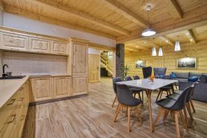 a kitchen and dining room with a table and chairs at Hotel&SPA Jawor in Zawoja