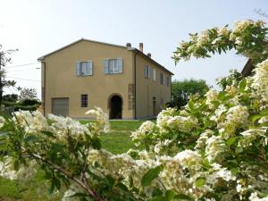 an old house with white flowers in front of it at Podere Bellavista - Agriturismo Bella Valle in Vada