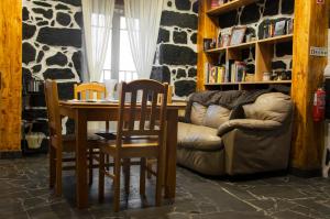 salon ze stołem, krzesłami i kanapą w obiekcie Stone Dreams - Pedra da Atafona w mieście Calheta de Nesquim