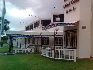 圣罗莎Hotel Lihuel Calel的一座白色的大建筑,在草地上设有大门